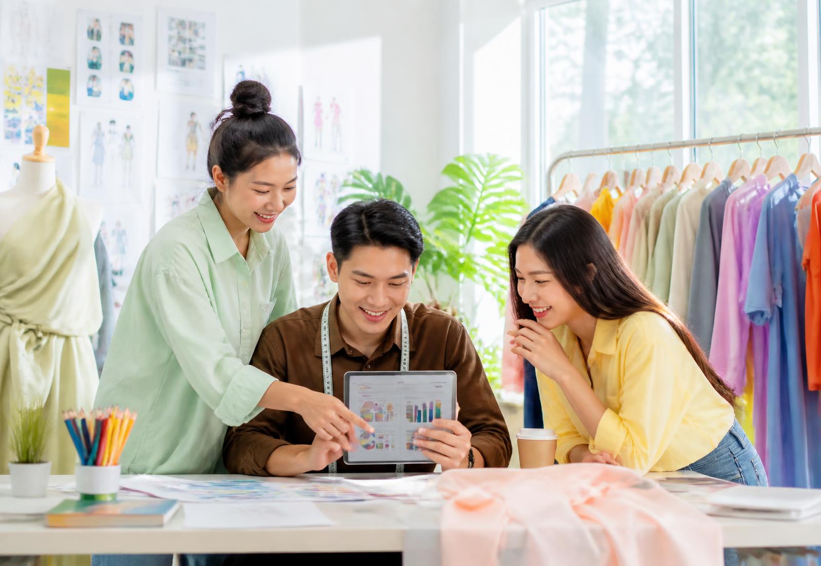 Đội thiết kế thời trang xem báo cáo xu hướng trên máy tính bảng